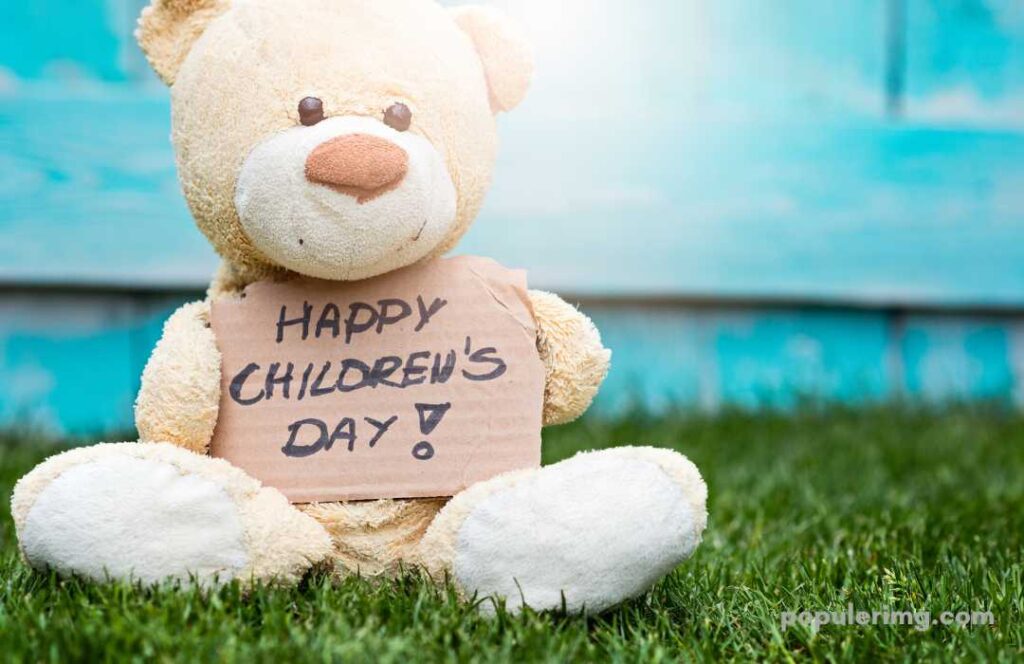 In This Image, A Teddy Bear Is Kept With Happy Children'S Day Written On His Hand
