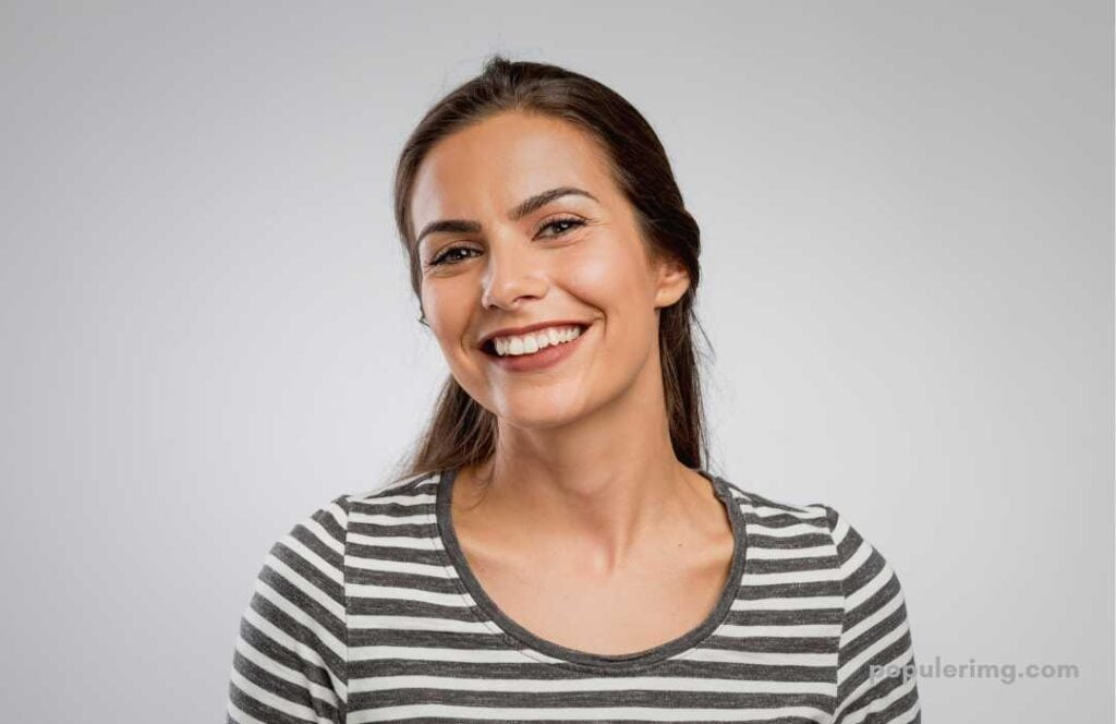 A Smiling Image Of A Lady Wearing A Gray And White  Design T-Shirt