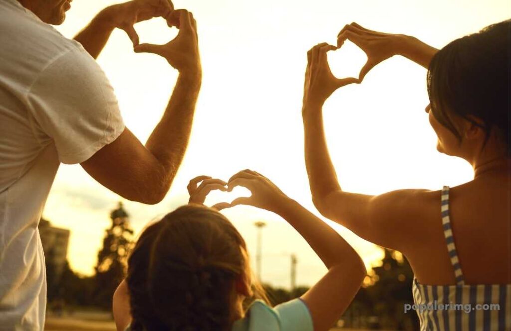 Mother Father And Daughter Raising Their Hands To The Sky Forming A Heart