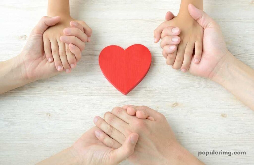 Parent And Child Holding Each Other'S Hand A Heart Between Them