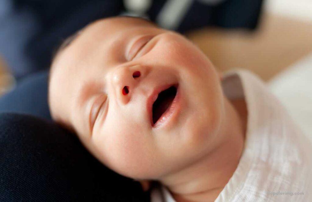 A Close Up Of A Baby With His Mouth Open.	