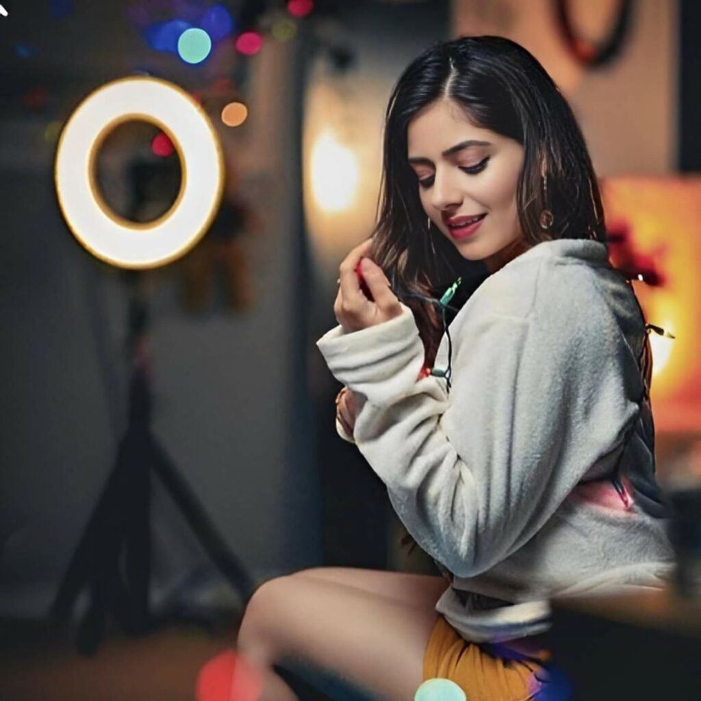 a young woman posing with a light ring around her neck.	