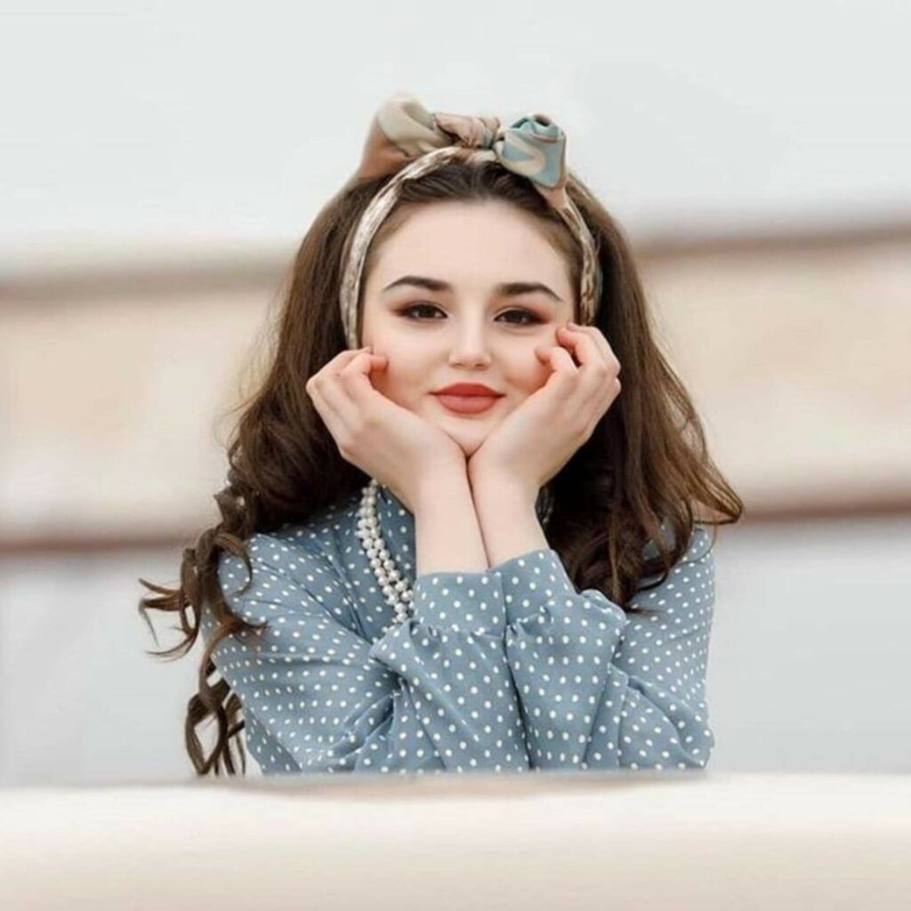 a young woman wearing a polka dot dress and a polka dot headband.	